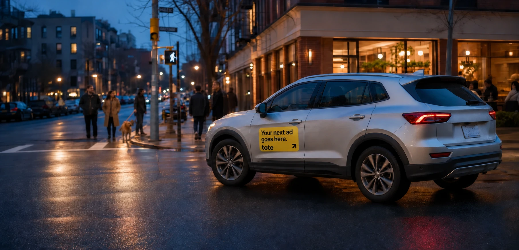A silver crossover with a standard Tote door panel moving through a neighborhood after sunset